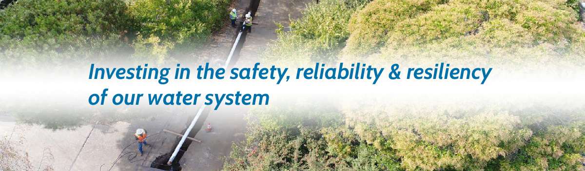 Marin Water staff lay new underground pipeline in roadway. Text reads "Investing in the safety, reliability & resiliency of our water system."