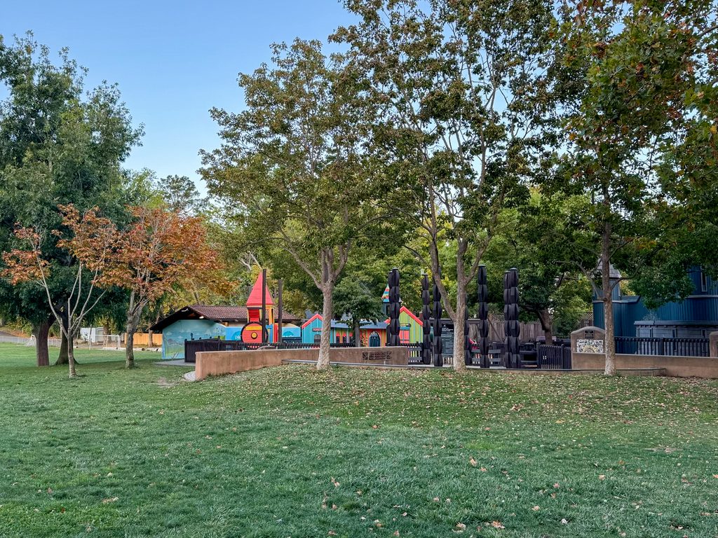 Image shows a playground surrounded by grass. 