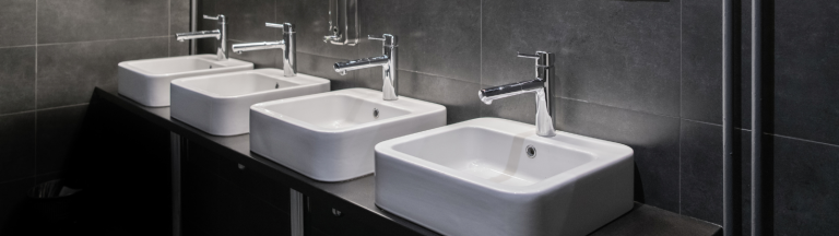 Image shows four sinks in a commercial restroom.